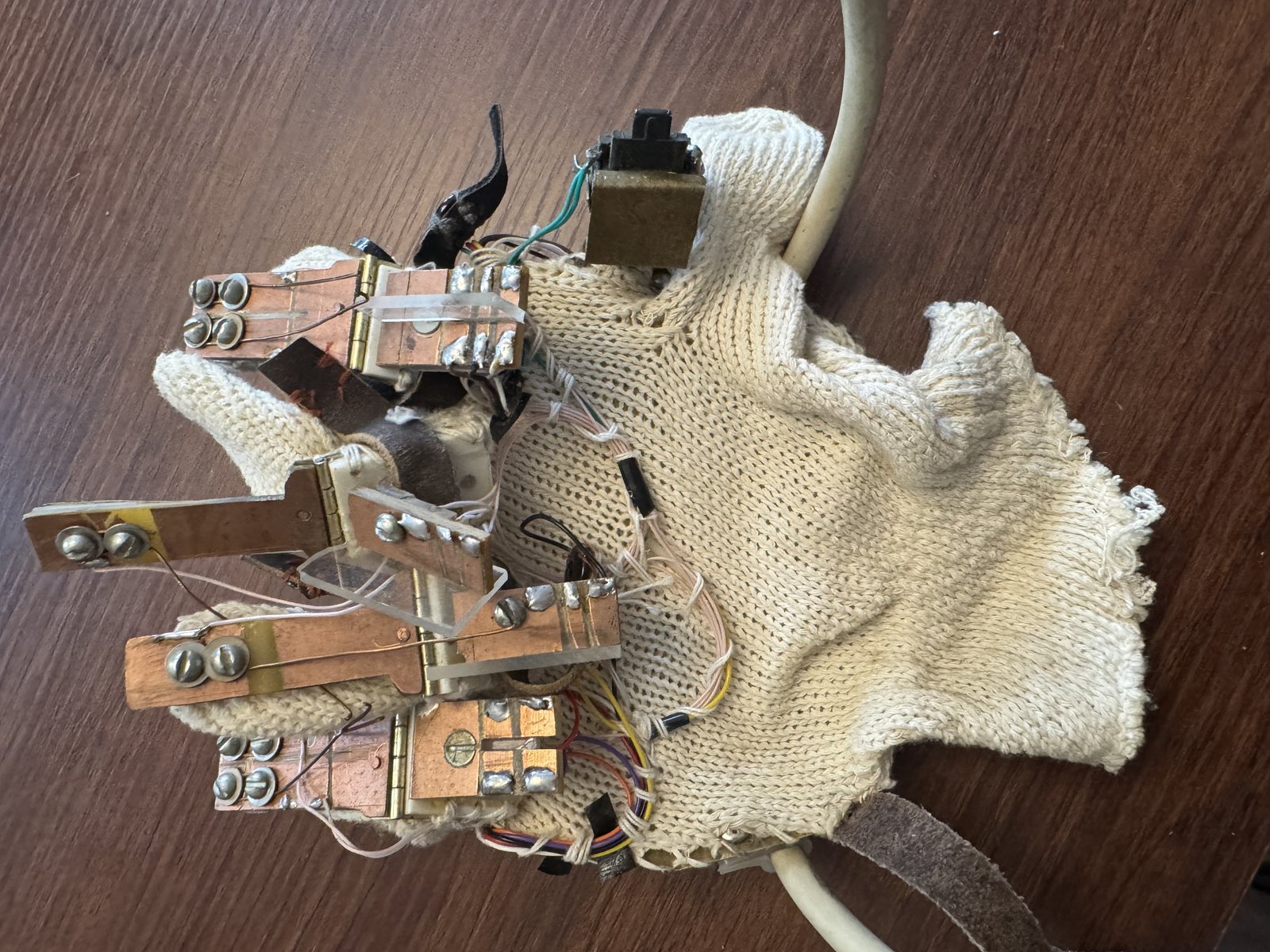 Close-up of the c. 2001 sensor glove's hinge-and-leaf-spring mechanism, hand-soldered to brass mounting plates.