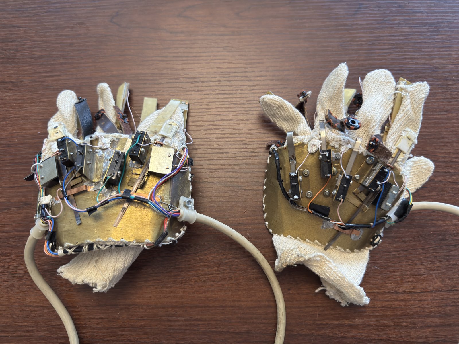 An actual c. 2001 sensor glove — switches, resistors and wiring mounted on brass plates sewn to knit glove fabric.