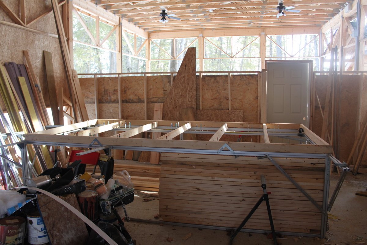 The framed wall on the table inside the timber-frame building it was built for.